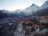 201 Annapurna Base Camp Before Sunrise - Annapurna III,  Gabelhorn, Machapuchare Annapurna Sanctuary Base Camp is a collection of stone huts surrounded by mountains and glaciers at around 4130m. This was the site of Chris Bonington�s Base Camp for the 1970 British expedition that completed the first ascent of the Annapurna South Face. I was up early and walked in the -1C clear weather for ten minutes to the monument hill. Before the sun started rising, I looked back to the east of Annapurna Sanctuary Base Camp to see the ridge connecting Annapurna III (7555m) to Gandharva Chuli (Gabelhorn, 6248m) to Machapuchare (6993m).